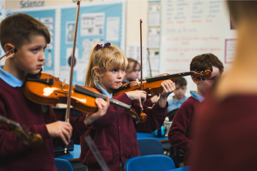 Year 3/4 pupils playing violin