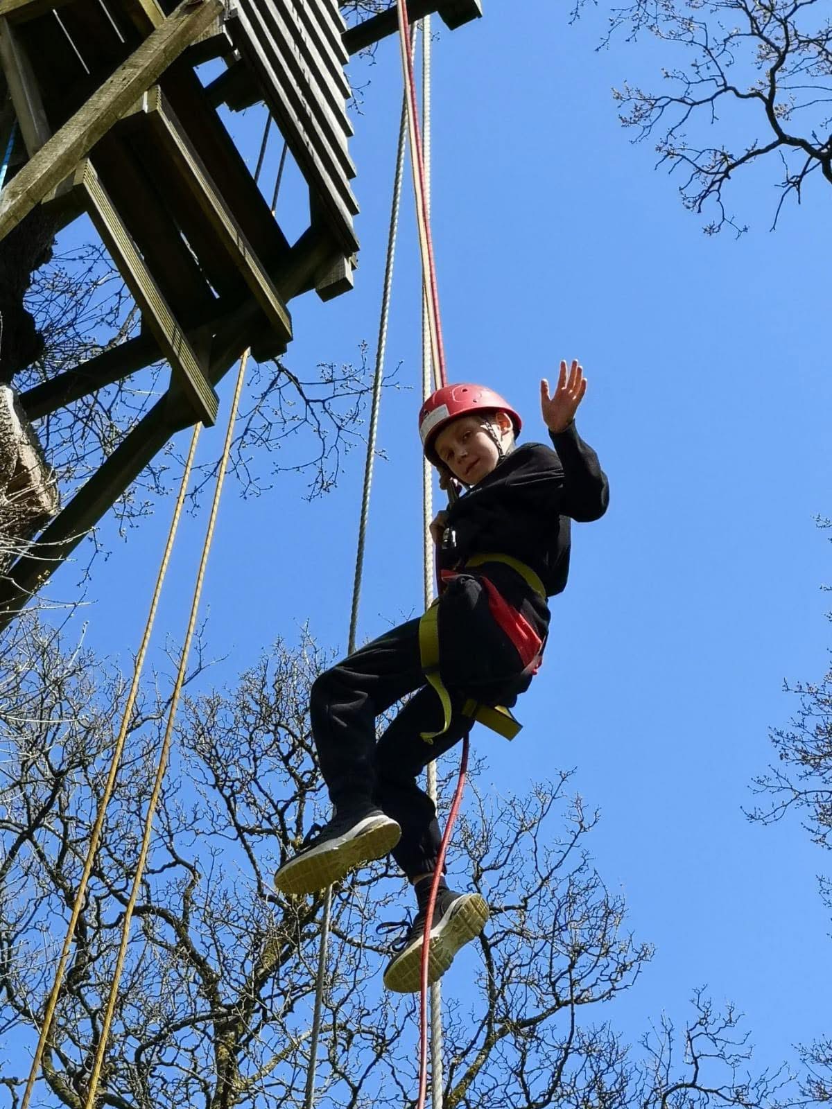 Pupil dangling mid air on high ropes course