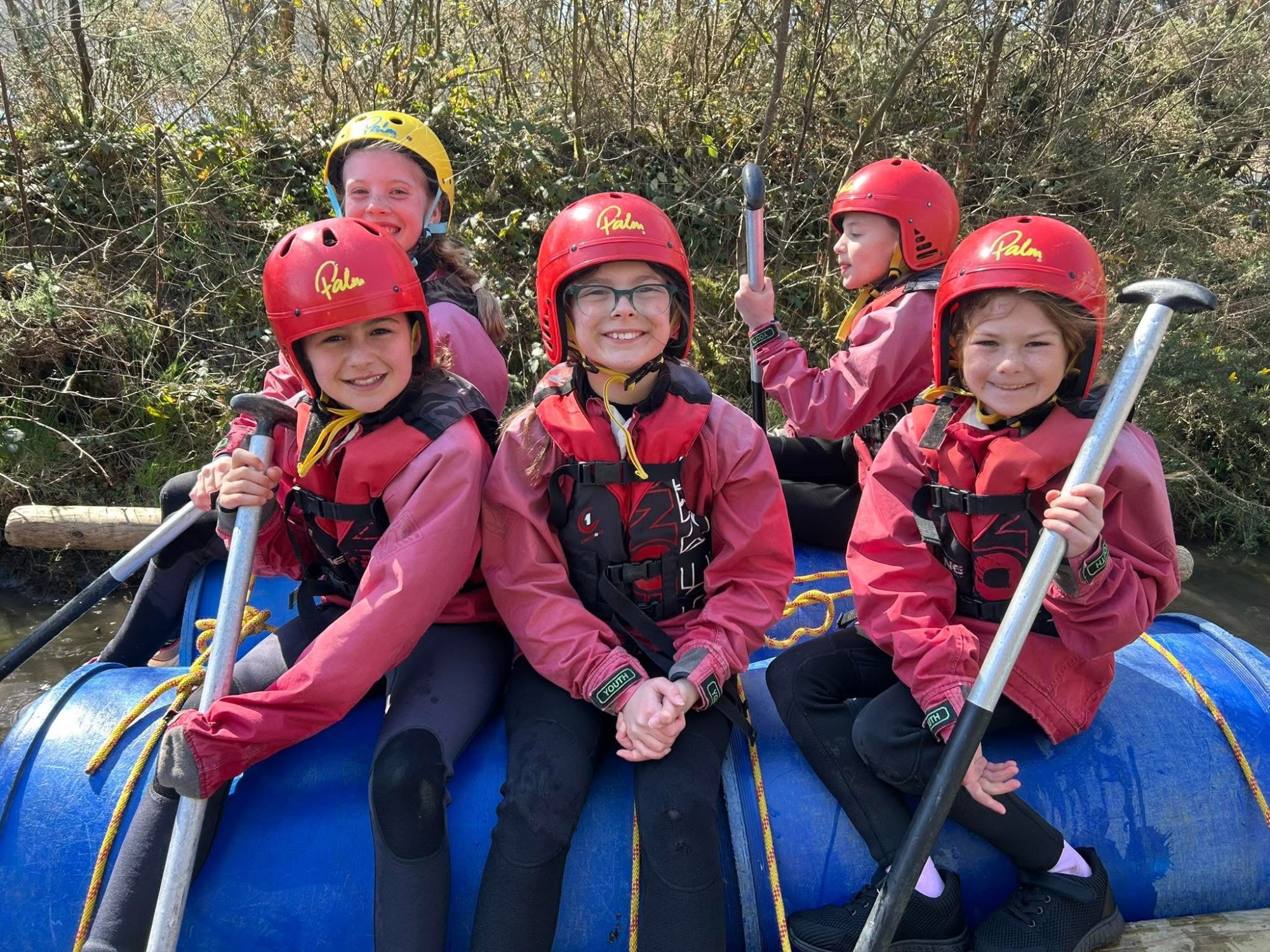 Pupils in wetsuits and buoyancy aids getting ready to paddle